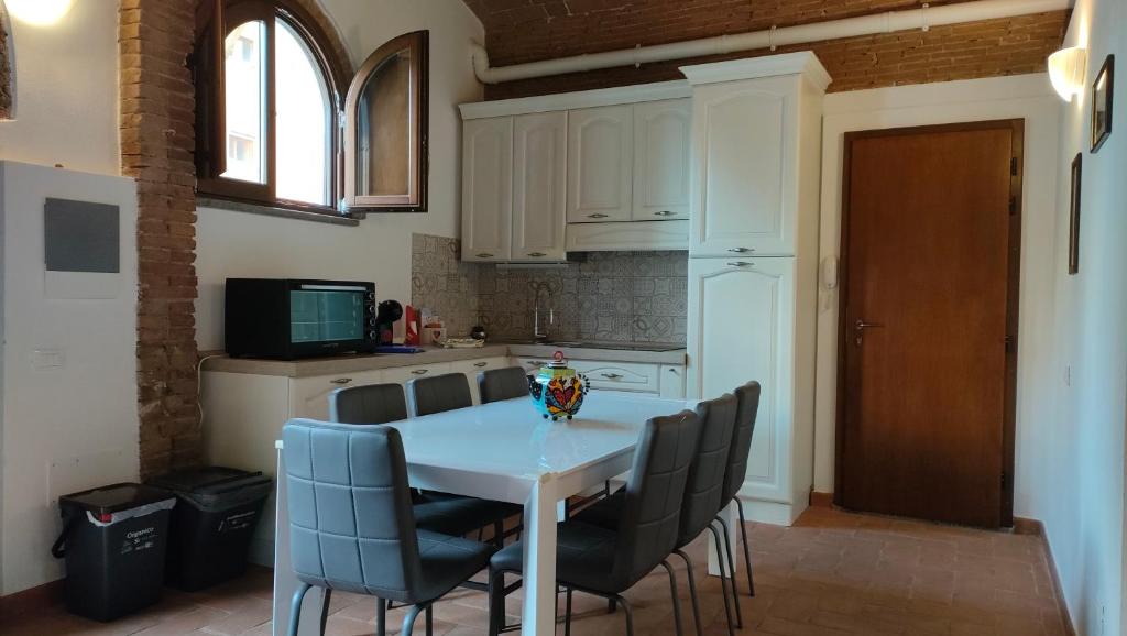 een keuken met een witte tafel en stoelen bij La Taverna di Maria in Suvereto