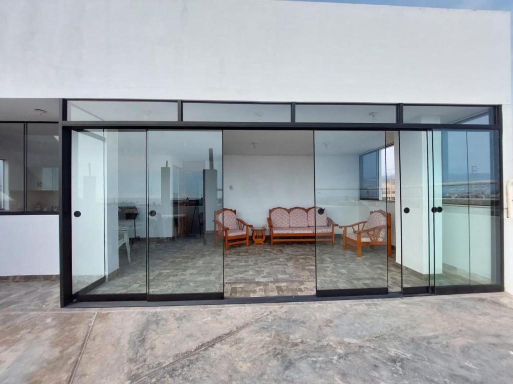 a glass house with a table and chairs in it at Departamento exclusivo Punta Negra in Punta Negra