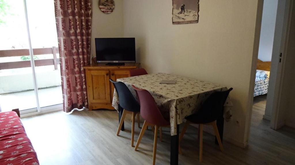 a dining room table with chairs and a television at Résidence Soleil D'aure - Appartement 4 personnes à deux pas du centre MAE-3564 in Cadeilhan-Trachère