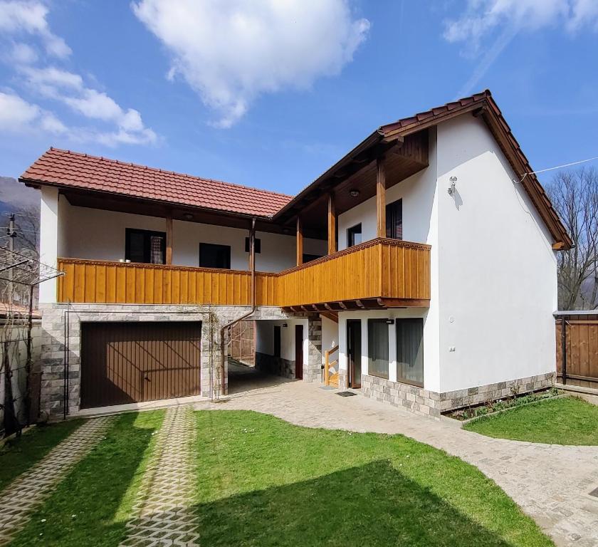 a house with a balcony and a yard at Casa de Vacanță Zabpatak Vendégház in Rimetea