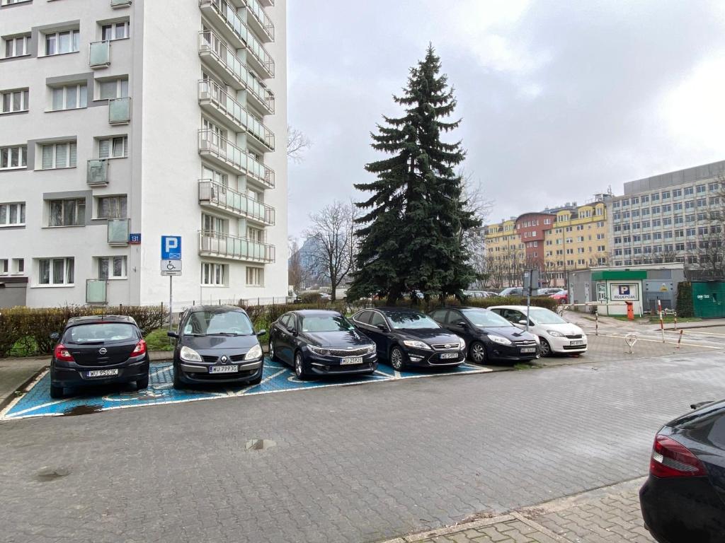a row of cars parked in a parking lot with a christmas tree at Warszawa Zachodnia in Warsaw