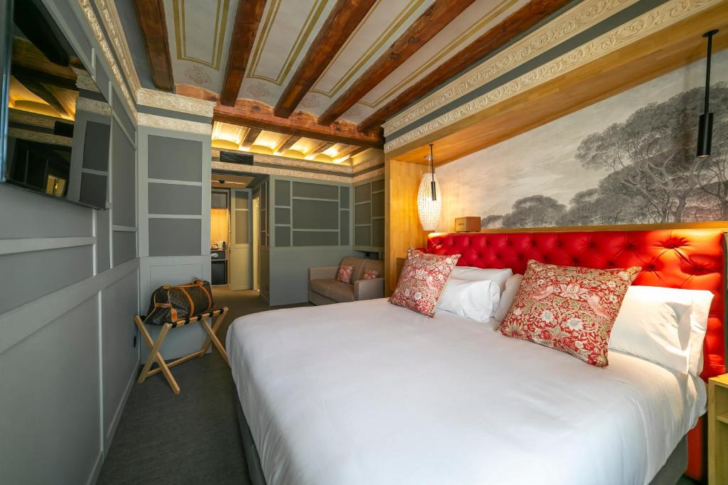 a bedroom with a large bed with a red headboard at Hotel La Pau in Barcelona