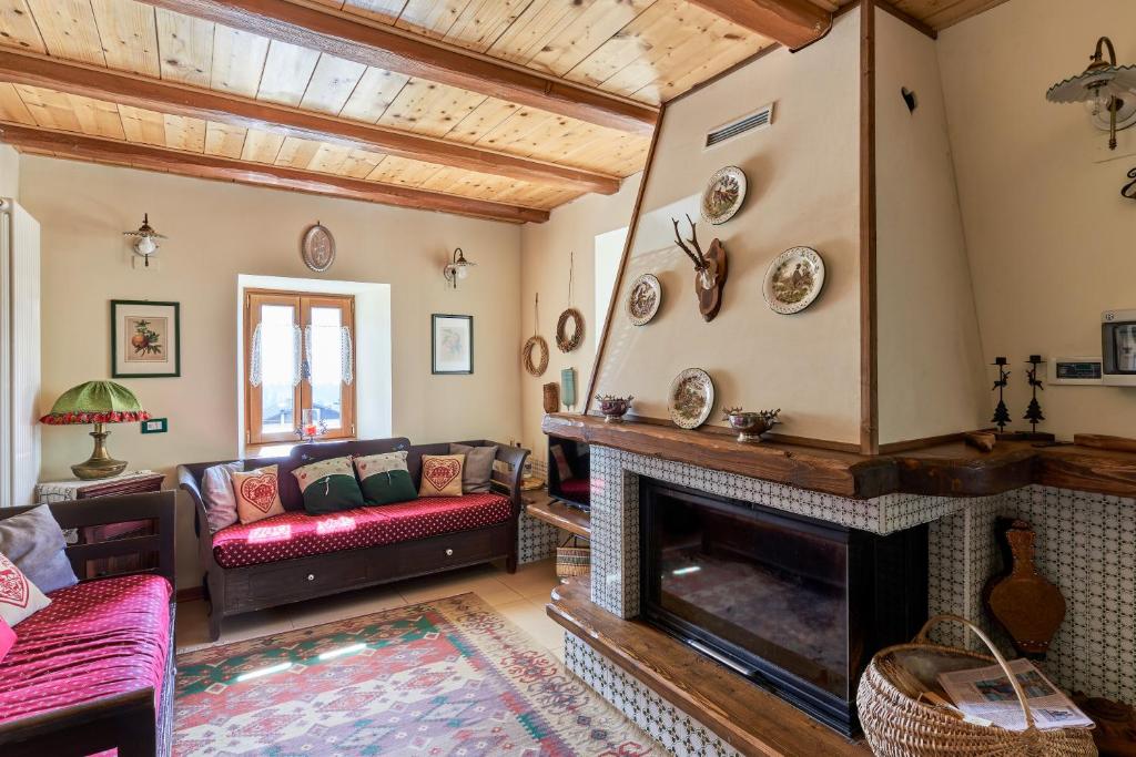 a living room with a fireplace and a couch at Conte Moro, ospitalità in Vanoi in Canale San Bovo