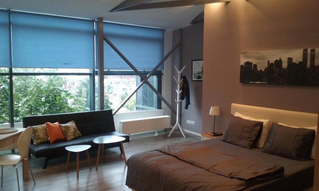 salon z łóżkiem i dużym oknem w obiekcie Heights Accommodation Unirii Free Parking Zone w Bukareszcie