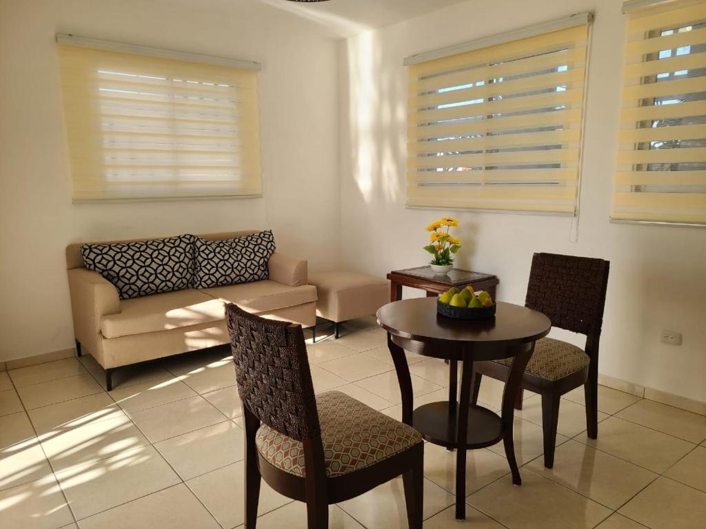 a living room with a table and chairs and a couch at Apartamentos LC cerca de la playa in La Romana