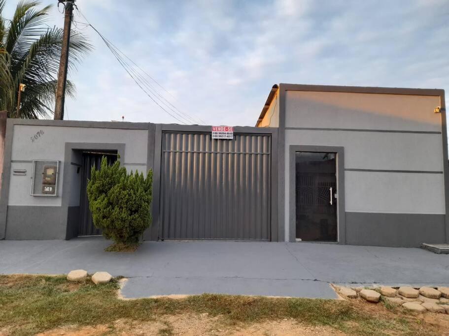 un bâtiment gris et blanc avec un garage dans l'établissement Casa para o Rondônia Rural Show, à Ji-Paraná