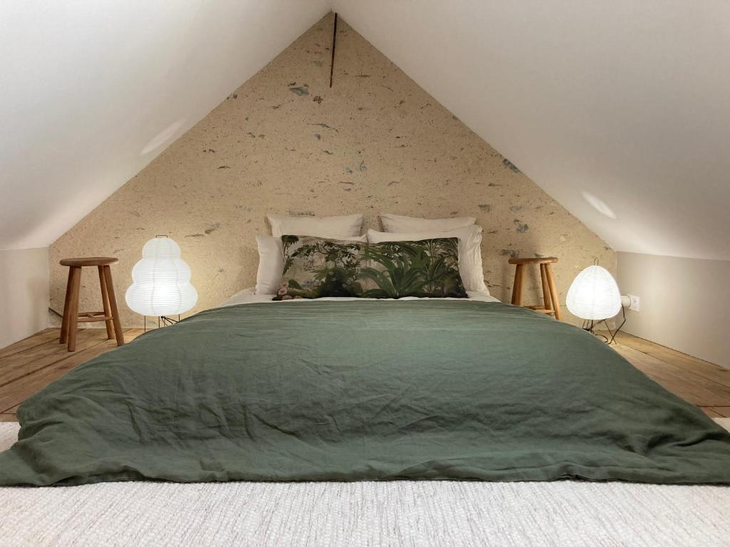 una camera da letto con un grande letto verde con due lampade di Ô Bord de Loire a Denée