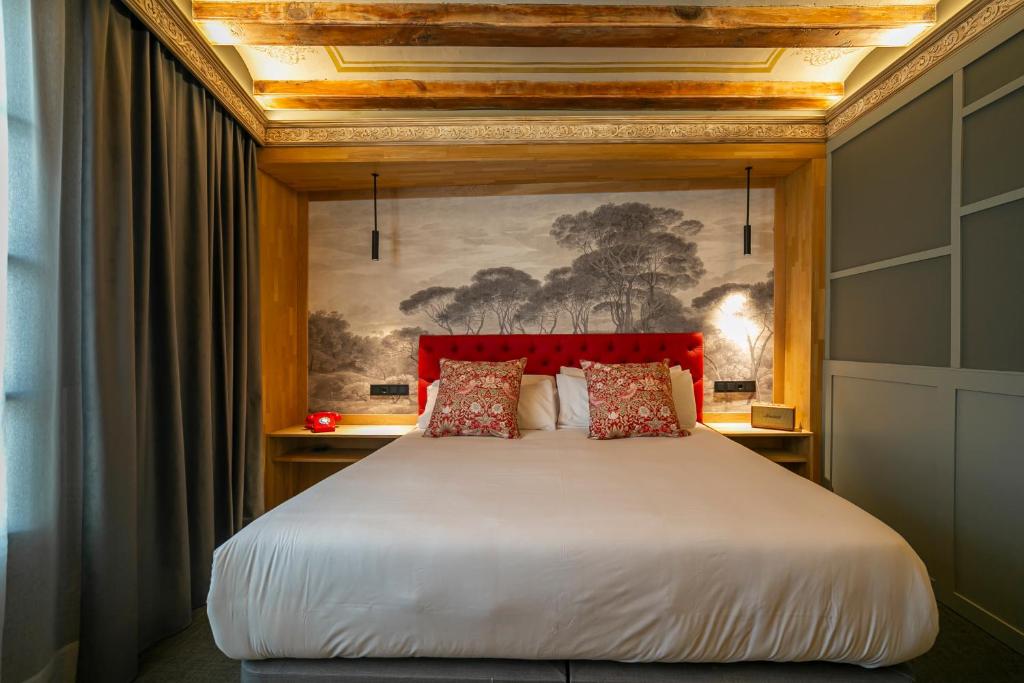 a bedroom with a large bed with a red headboard at Hotel La Pau in Barcelona