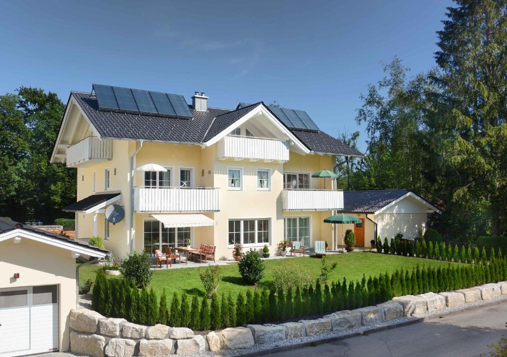 ein Haus mit Sonnenkollektoren auf dem Dach in der Unterkunft Am Badezentrum Ferienwohnungen in Ruhpolding
