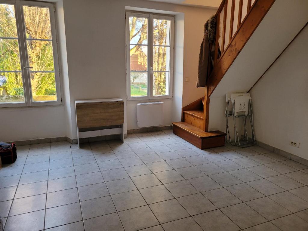 an empty room with a staircase and a tiled floor at Duplex à Yerres in Yerres
