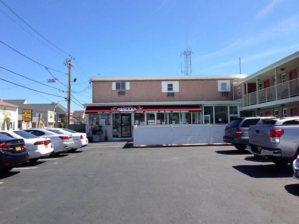 a parking lot with cars parked in front of a building at Anchor Motel in Seaside Heights