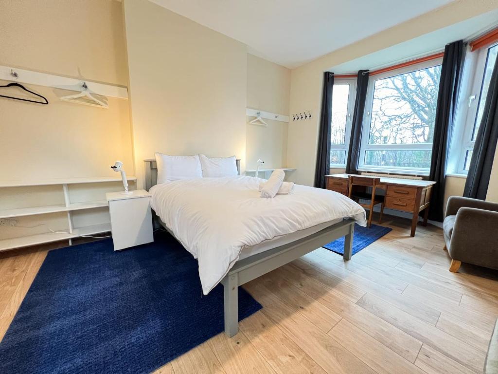 a bedroom with a large bed with a blue rug at West End Gem 3BR Detached Family House in Glasgow