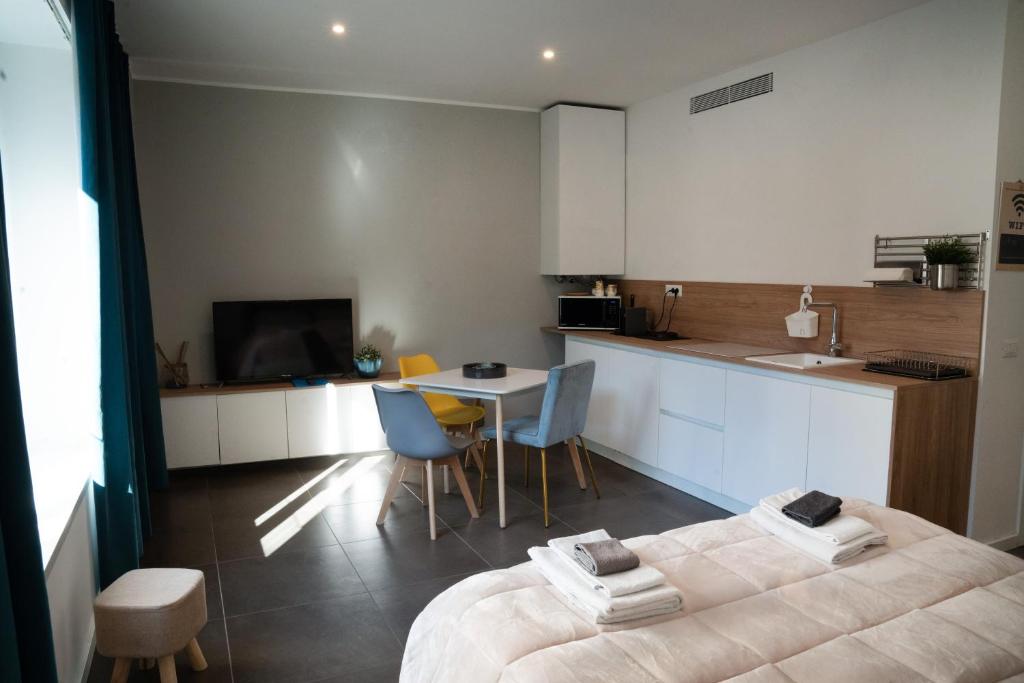 a room with a bed and a kitchen with a table at Bubi House Porta Romana in Milan