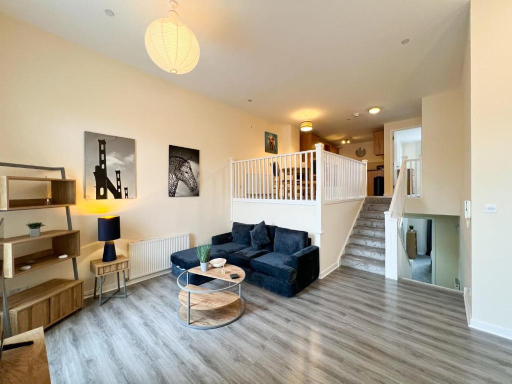 uma sala de estar com um sofá azul e uma escada em Duplex Apartment in Glasgow em Glasgow