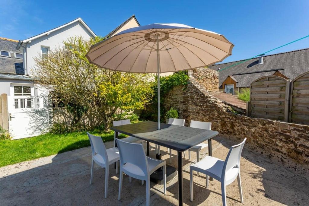 einen Tisch und Stühle mit Sonnenschirm auf einer Terrasse in der Unterkunft Ker Roz - Belle maison 3 chambres- Proche Mer-Port in Cancale