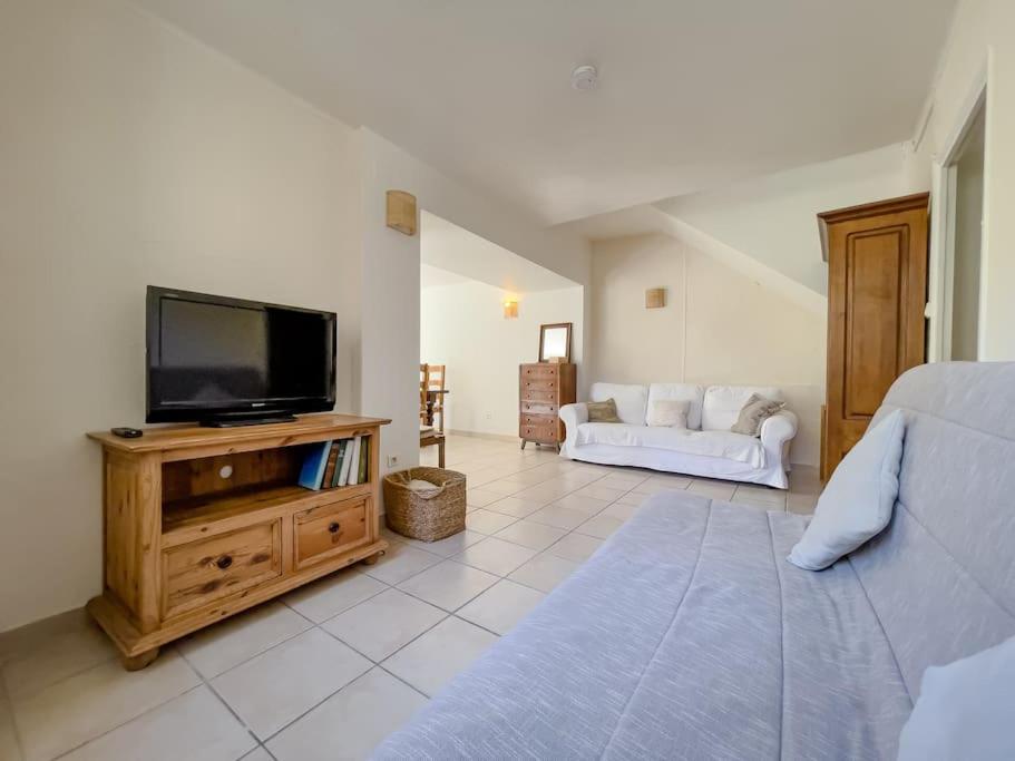 オーティニャックにあるCharmante Maison de Village - Plages 30'のリビングルーム(木製キャビネット上のテレビ付)