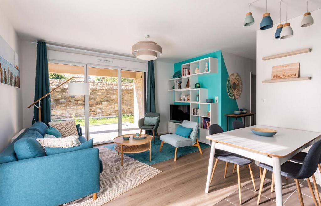 ein Wohnzimmer mit einem blauen Sofa und einem Tisch in der Unterkunft Le Celadon - Joli T3 moderne - 2 chambres avec in Cancale