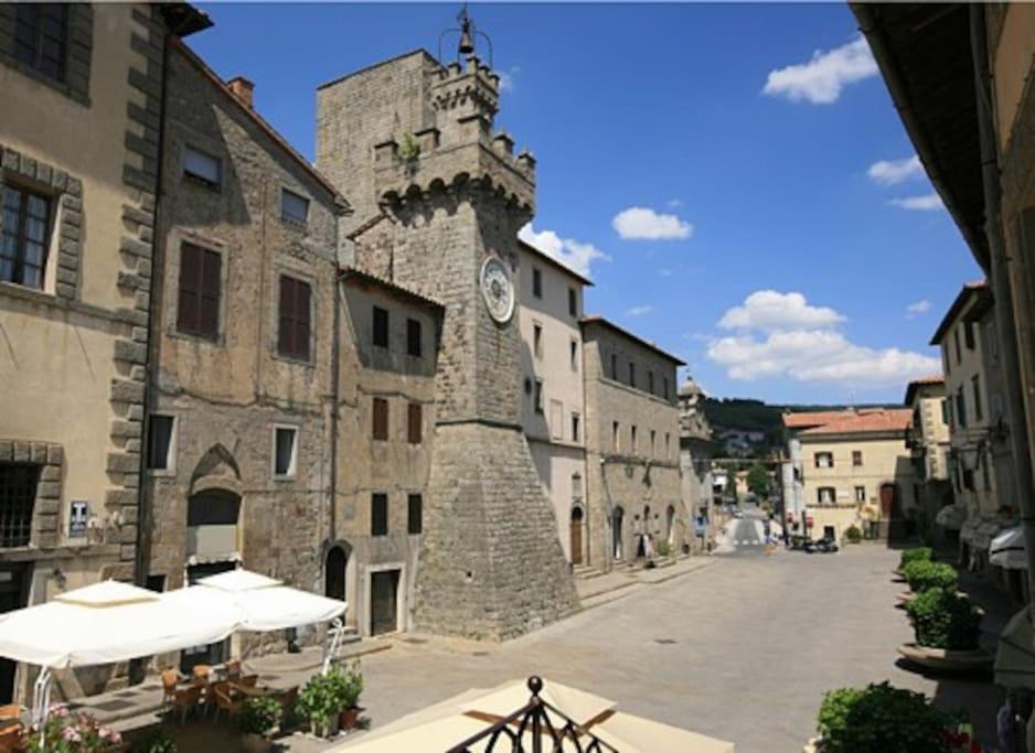 un edificio in pietra con una torre dell'orologio su una strada di Monteluce a Santa Fiora