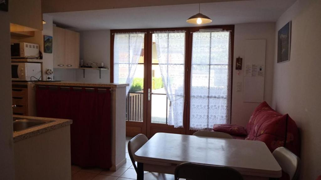 eine Küche und ein Wohnzimmer mit einem Tisch und einem Sofa in der Unterkunft Résidence Eugenie - 2 Pièces pour 4 Personnes 964 in Guchen