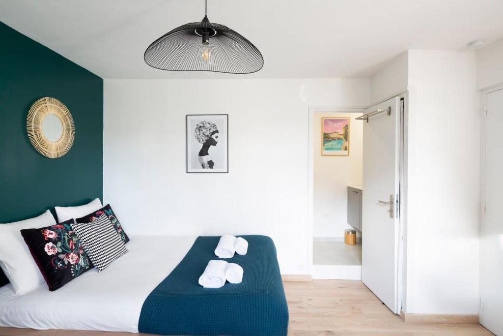 1 dormitorio con cama blanca y pared verde en L'éden studio moderne et lumineux proche centre, en Rennes