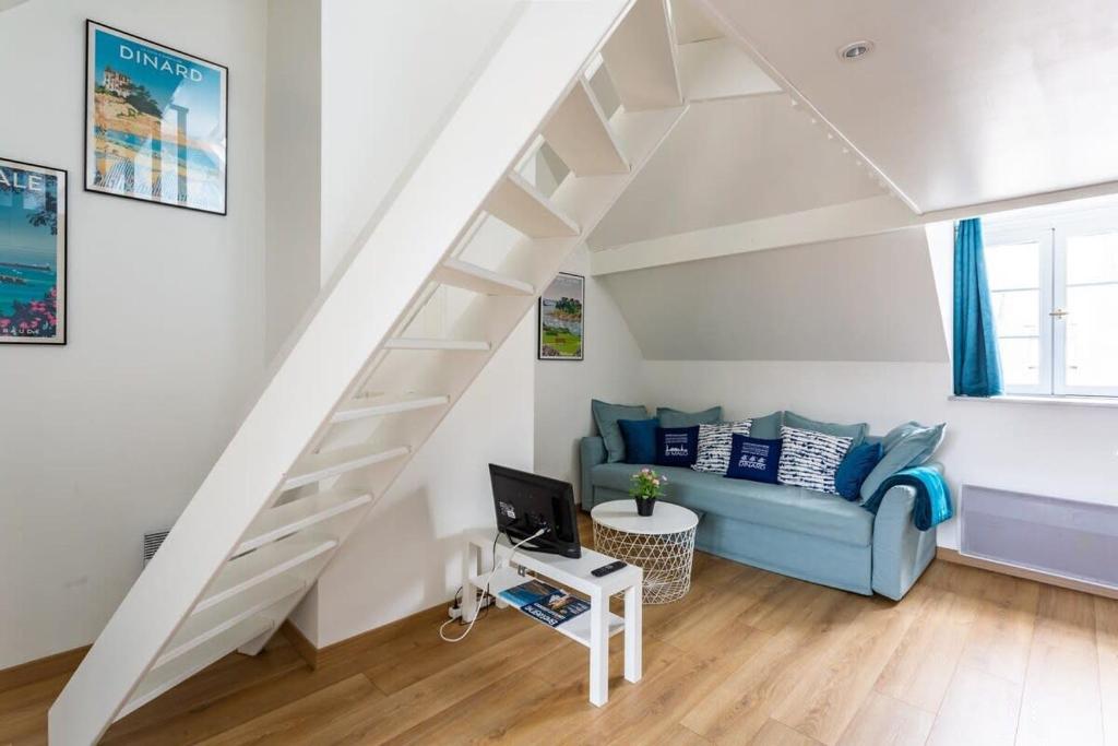 een woonkamer met een blauwe bank en een trap bij Le Petit Pastel - Joli duplex - Proche de la plage in Saint-Malo