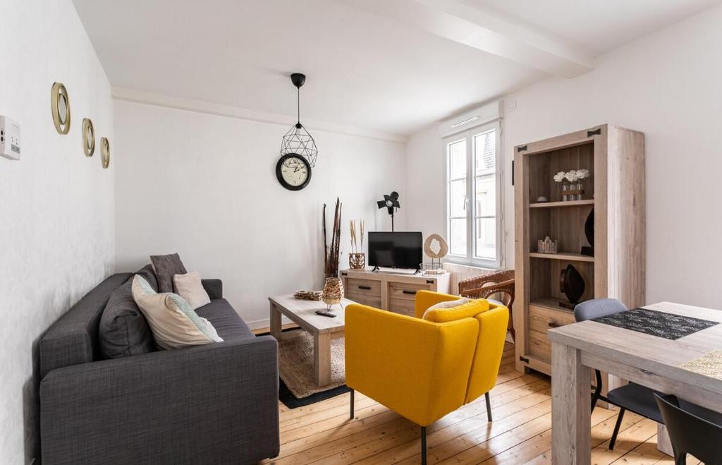 uma sala de estar com um sofá e uma mesa em Le Gardelle - Jolie maison de ville (2 chambres) em Saint Malo