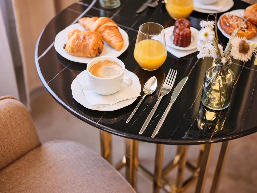 a table topped with plates of pastries and a cup of coffee at Maison Heym Bordeaux in Bordeaux