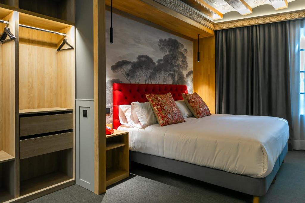 a bedroom with a bed with a red headboard at Hotel La Pau in Barcelona