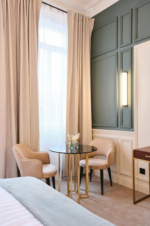 a room with a table and chairs and a bed at Maison Heym Bordeaux in Bordeaux