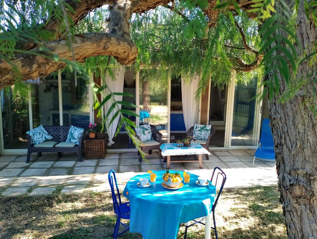 a table under a tree on a patio at Appartamento in Villa Siciliana in Ognina