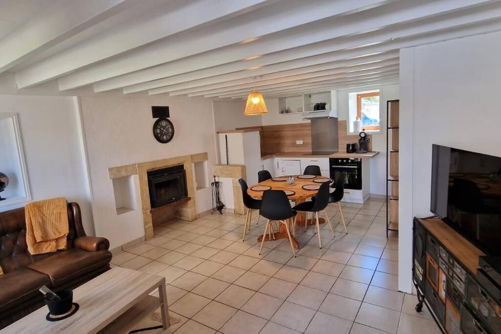 een keuken en woonkamer met een tafel en stoelen bij Petite maison de La Hague in Beaumont-Hague