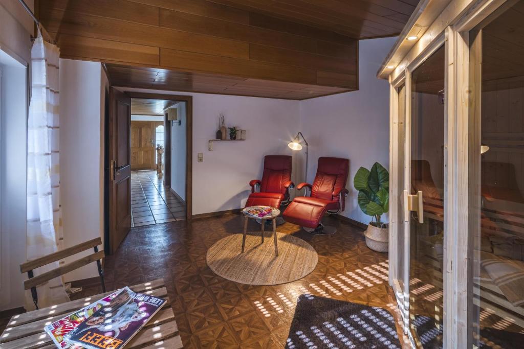 a living room with two chairs and a table at Das Schmitz Haus in Meckel
