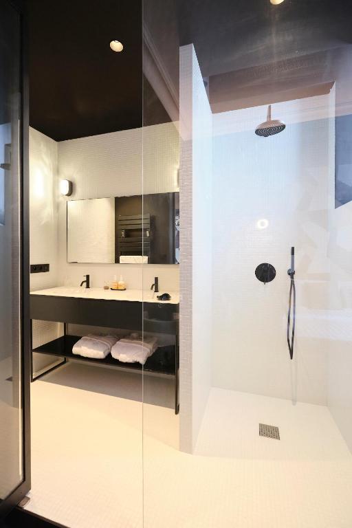 a bathroom with a glass shower and a sink at Maison Heym Bordeaux in Bordeaux