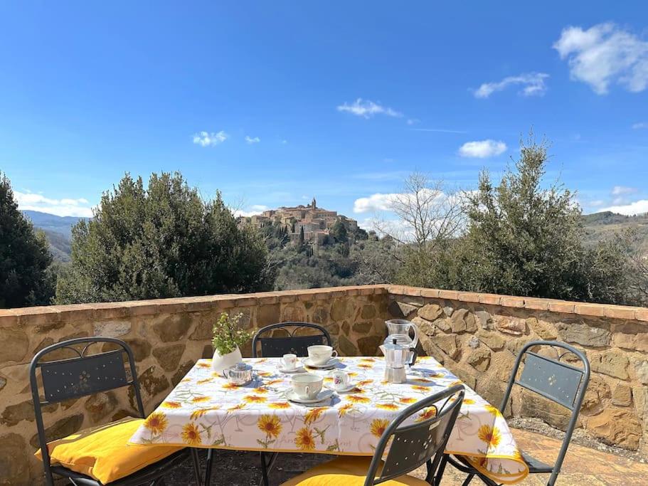 a table and chairs sitting on a stone wall with a table and chairs at Tuscany Panoramic View - Relax in Val D'Orcia in Seggiano