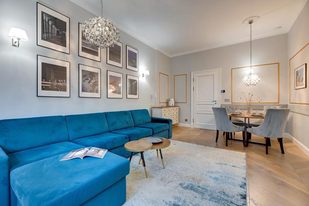 a living room with a blue couch and a table at Sopot Pod Orłem Monte Cassino by Downtown Apartments in Sopot