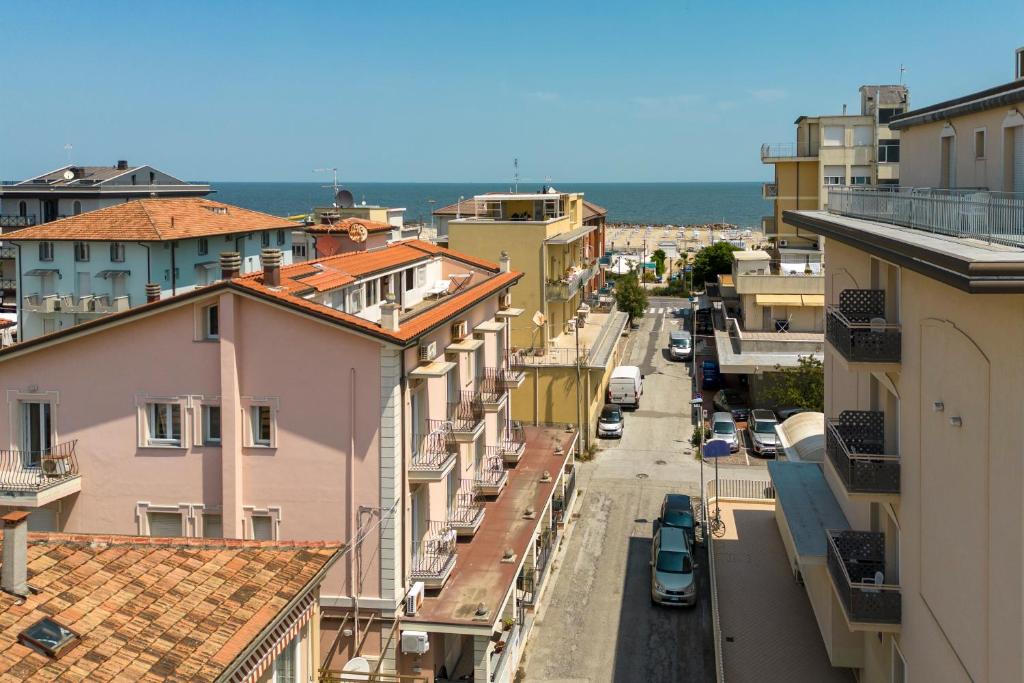 a city street with buildings and the ocean in the background at Residence Uno Studio&Suites in Rimini