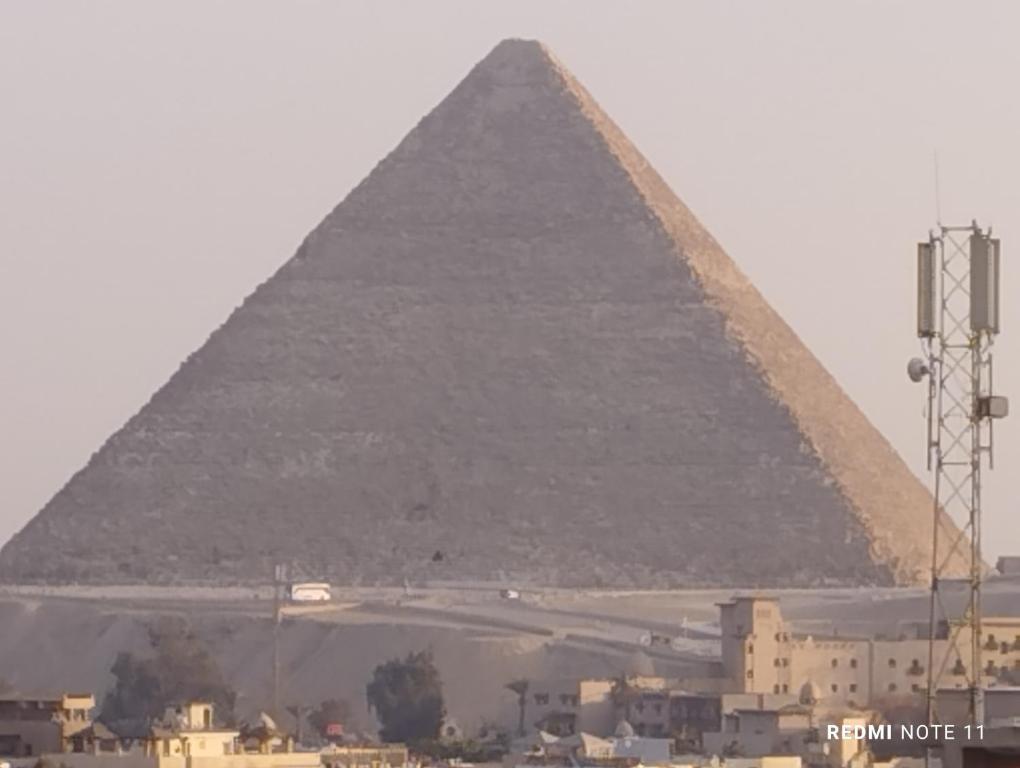 a view of the pyramids of giza and a city at Sneferu Pyramids inn - Full Pyramids View in Cairo