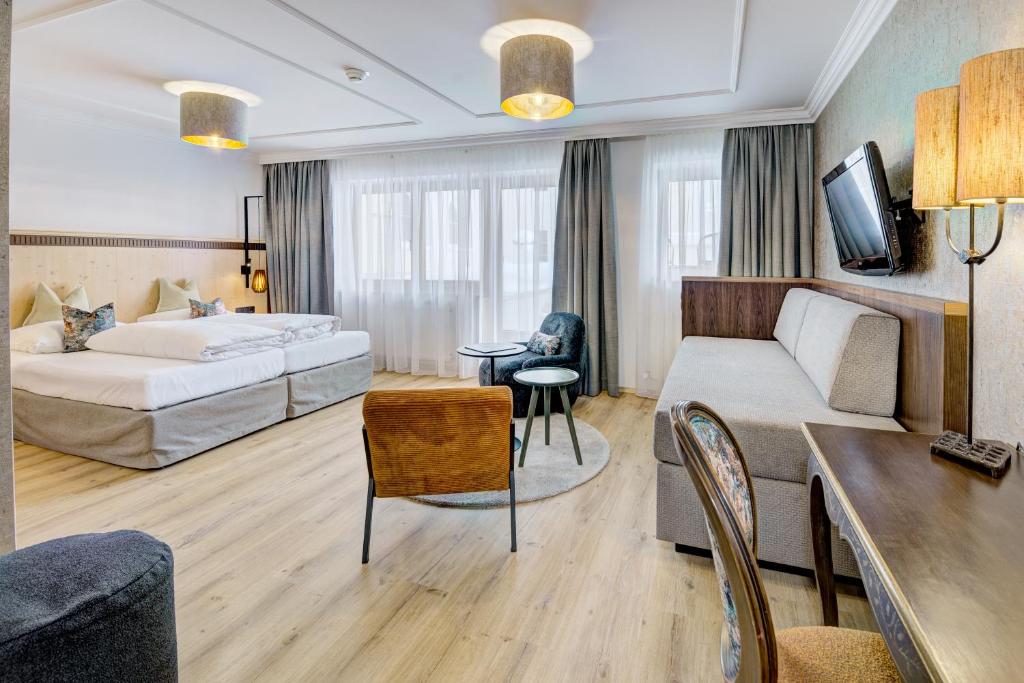 a hotel room with a bed and a couch at Hotel Brigitte in Ischgl