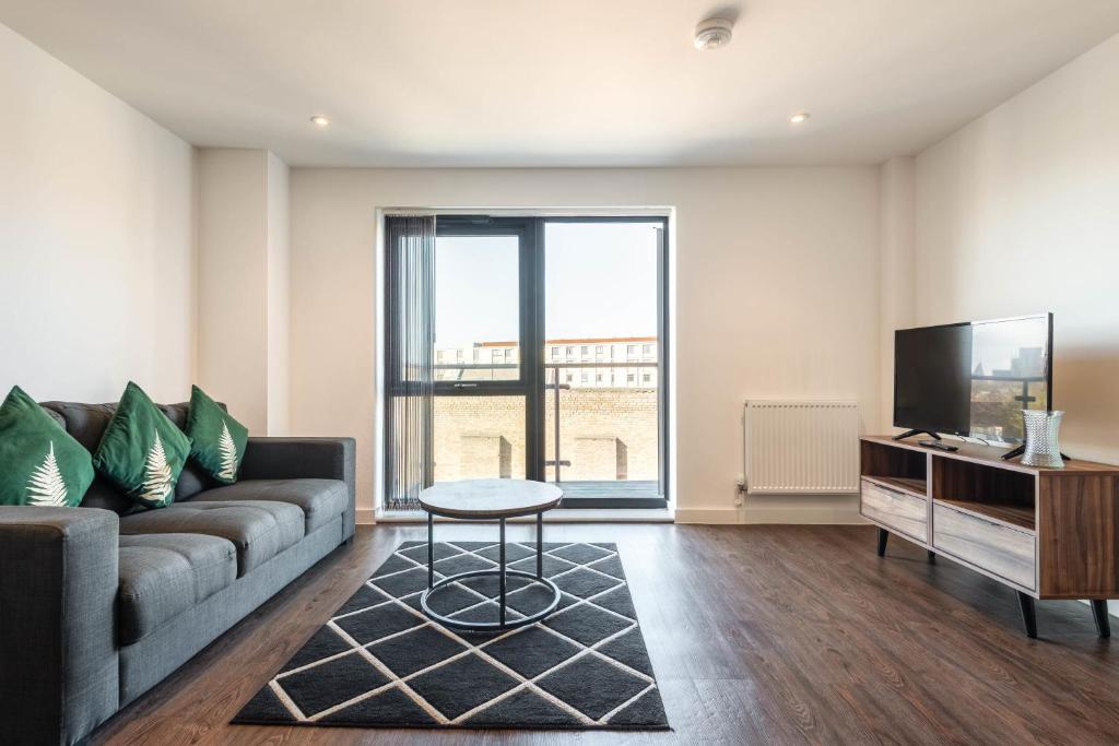 a living room with a couch and a tv at Modern 2 bed 2 bath apartment in the heart of York in York
