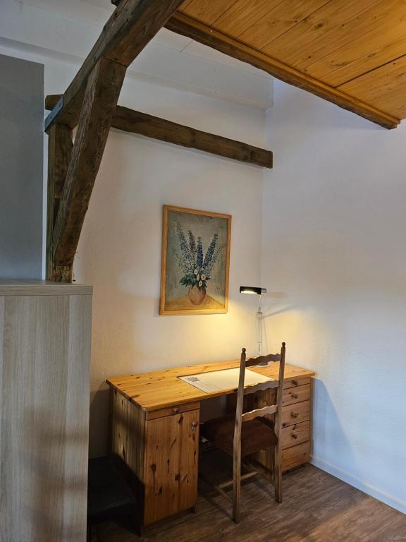 Cette chambre comprend un bureau en bois et une lampe. dans l'établissement Ferienwohnung im Dachgeschoss mit Aufzug, à Rostock