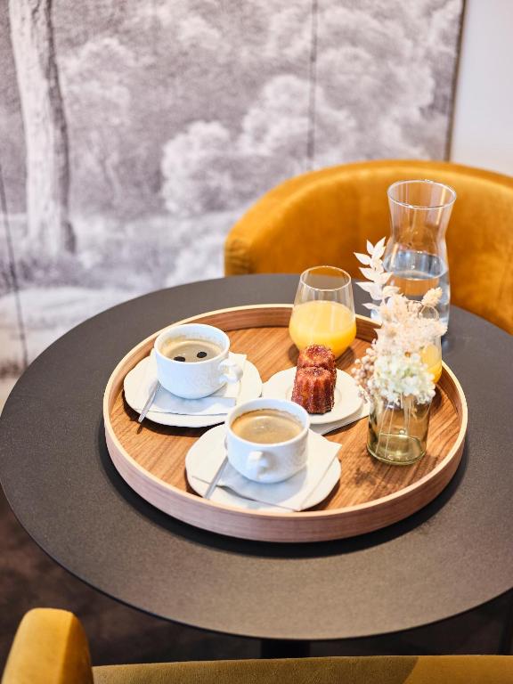a tray with two cups of coffee and food on a table at Maison Heym Bordeaux in Bordeaux