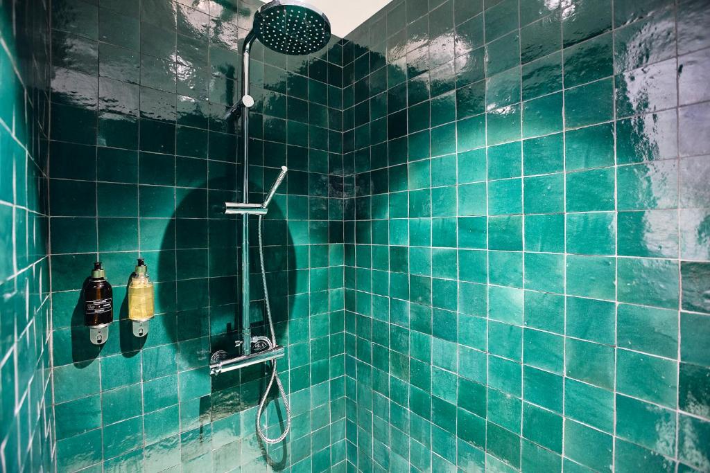 a blue tiled bathroom with a shower at Maison Heym Bordeaux in Bordeaux