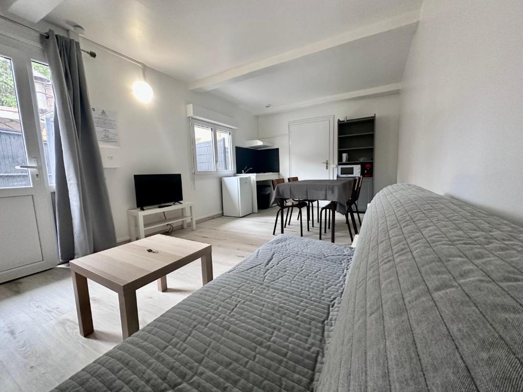 um quarto com uma cama, uma mesa e uma cozinha em 03 T2 Immeuble Le GD em Jarny
