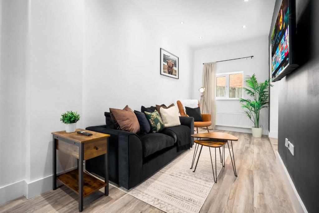 - un salon avec un canapé noir et une table dans l'établissement Stylish Apartment with Free Wifi & Netflix 49aG, à Rowley Regis