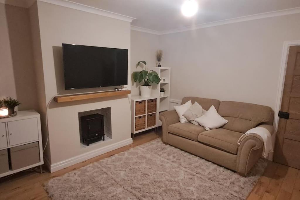 a living room with a couch and a flat screen tv at 3 Bed Home in Heart of Cardiff in Cardiff