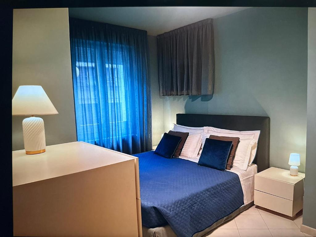 1 dormitorio con 1 cama con sábanas y almohadas azules en Comosole, en Como