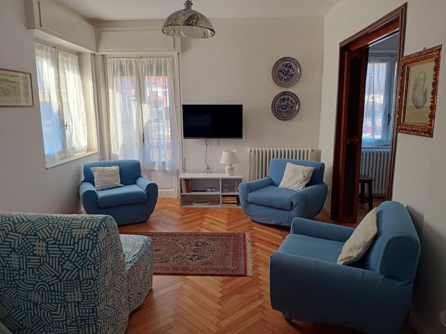 a living room with blue chairs and a tv at Casa Tina in Verbania
