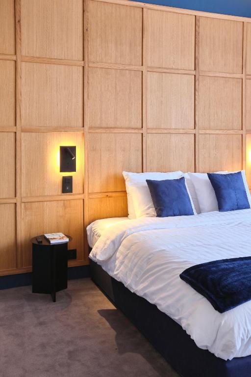 a bedroom with a large bed with a wooden headboard at Maison Heym Bordeaux in Bordeaux