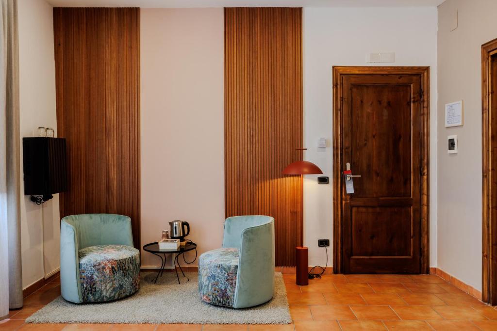 2 Stühle in einem Zimmer mit Tisch und Tür in der Unterkunft Palazzo della Città in Agnone