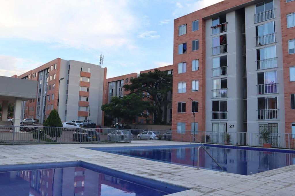 ein Apartmentkomplex mit einem Pool vor den Gebäuden in der Unterkunft Cómodo Apartamento Amoblado en Condominio in Cúcuta